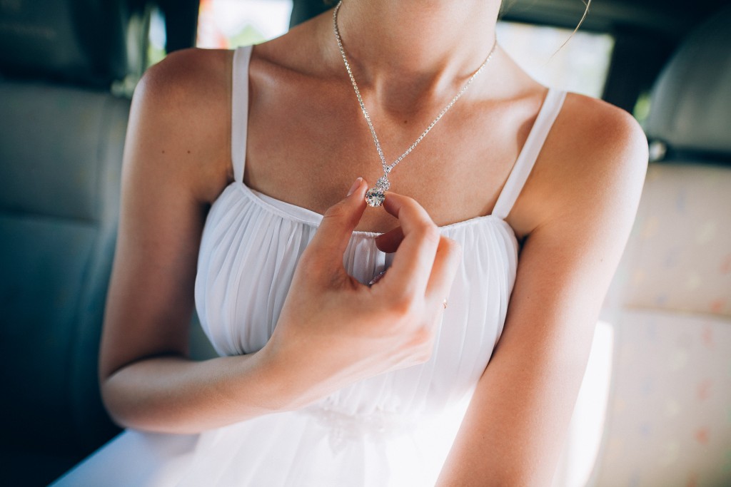 woman holding a pendant on her necklace